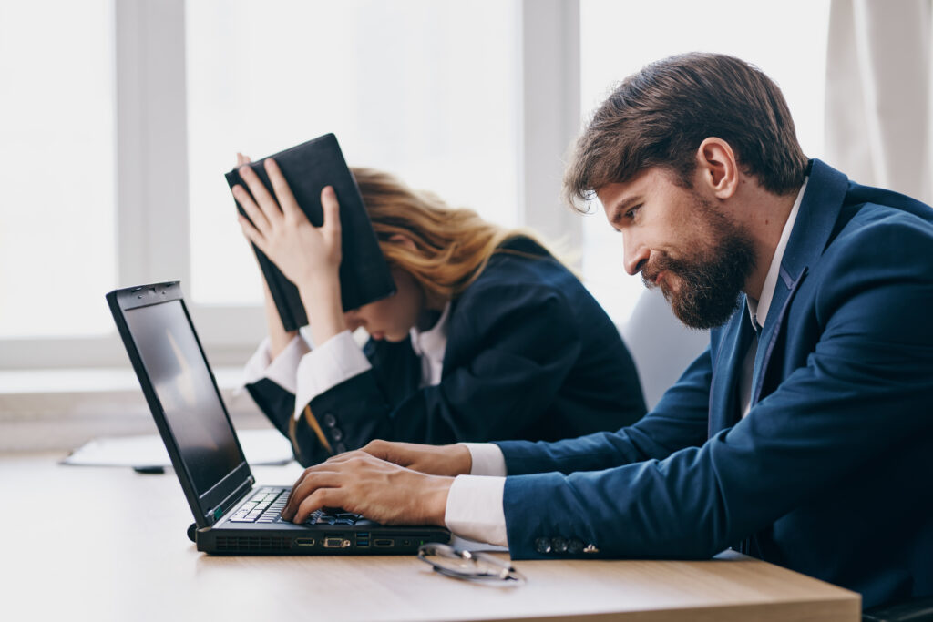 colleagues sitting in front of a laptop teamwork professionals looking for new clients because they don't have an SEO-optimized website